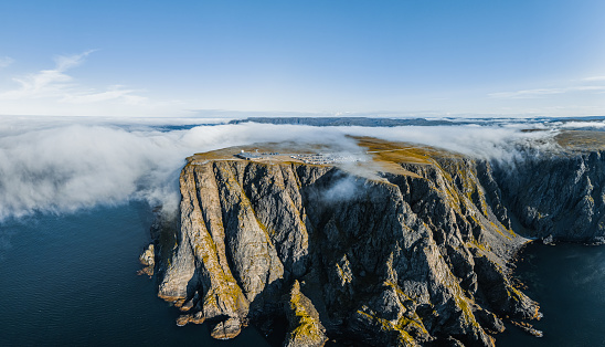 Aerial view of North Cape aka Nordkapp in summer with fog clouds over the landscape in Northern Norway