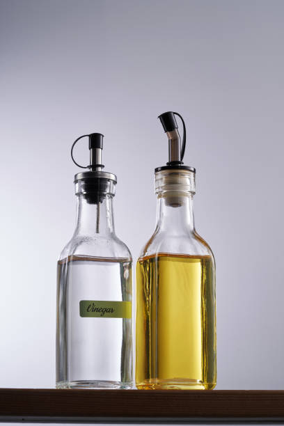 olive oil and white vinegar against white background olive oil and white vinegar against white background olive oil pouring antioxidant liquid stock pictures, royalty-free photos & images