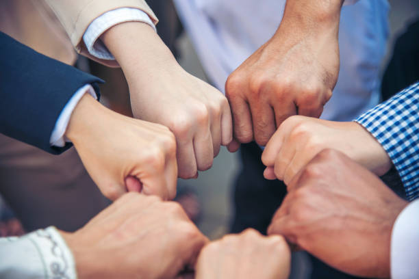 diversos parceiros multiétnicos juntam grupo de trabalho em equipe de pessoas multi-raciais se reunindo juntos. mãos de pessoas da diversidade se unem para capacitar equipes de parceria conexão comunidade voluntária - togetherness customer bonding business - fotografias e filmes do acervo