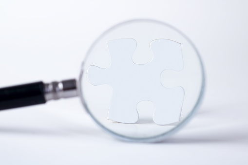 Magnifying glass and success Puzzle piece.
Magnifying glass searching for missing puzzle pieces on white background