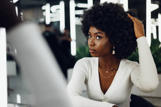 Young african woman customer getting a hairstyle at a beauty salon. Young african woman customer getting a hairstyle at a beauty salon, portrait natural hair stock pictures, royalty-free photos & images
