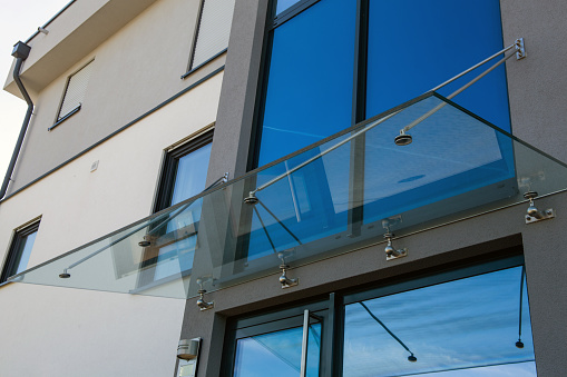 Closeup frameless laminated glass railing for modern architecture.
