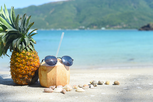 Pineapple with coconut drink and sunglasses