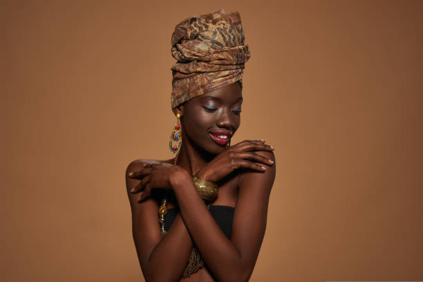 istock Black girl wearing african outfit hugging herself 1413953447