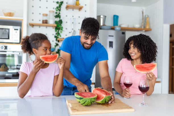 istock Dad is cutting watermelon while mom and daughter are watching him. 1413953588
