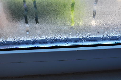 Rain falling on glass, textured background. Winter concept season