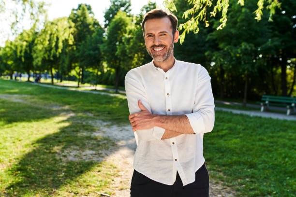 istock Smiling man standing at park during summer afternoon 1413954893
