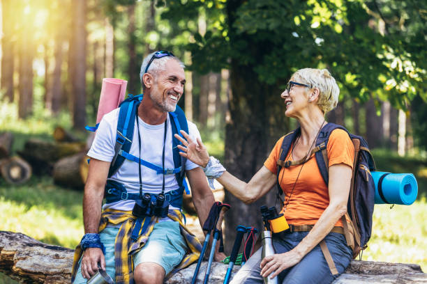 istock Mature couple sitting while resting in the forest after hiking 1413955060