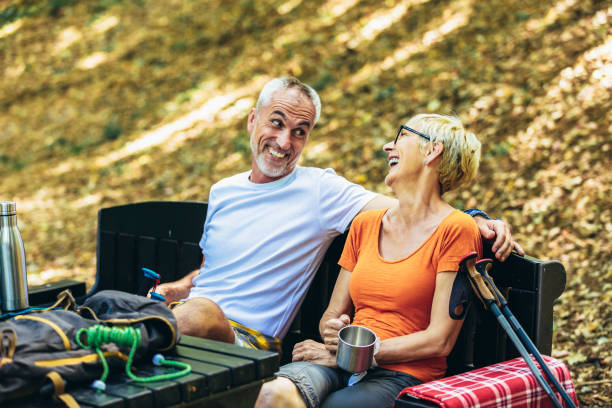 istock Mature couple sitting while resting in the forest after hiking 1413955244