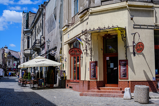 Bucharest, Romania - 6 May 2021: Old buildings with bars and restaurants on Lipscani Street (Strada Lipscani) in the historical center (Centrul Vechi) in a sunny spring day