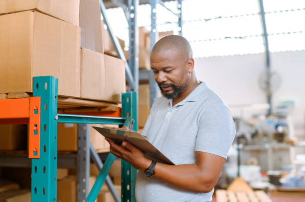 istock Taking stock, orders or notes while working as a logistics manager in a shipping and storage warehouse. Factory supervisor counting packages, items and cardboard boxes for import and export delivery 1413958029
