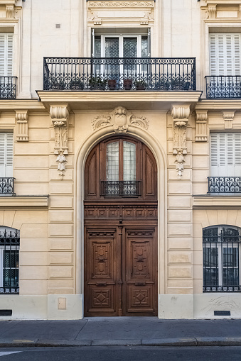 White plastic entrance door and facade decorations with plants.