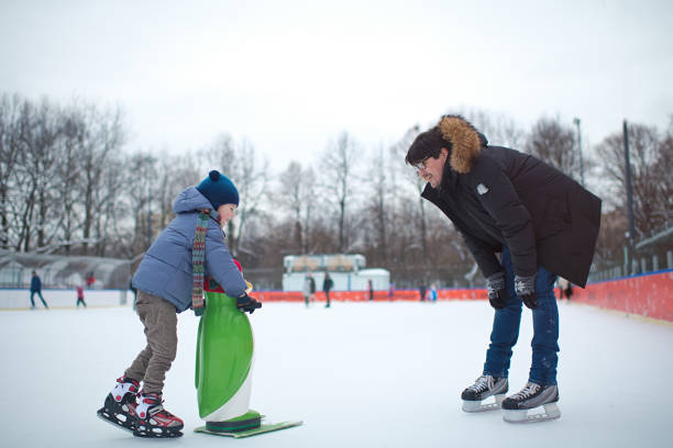 Child learns ice-skating using a helper penguin