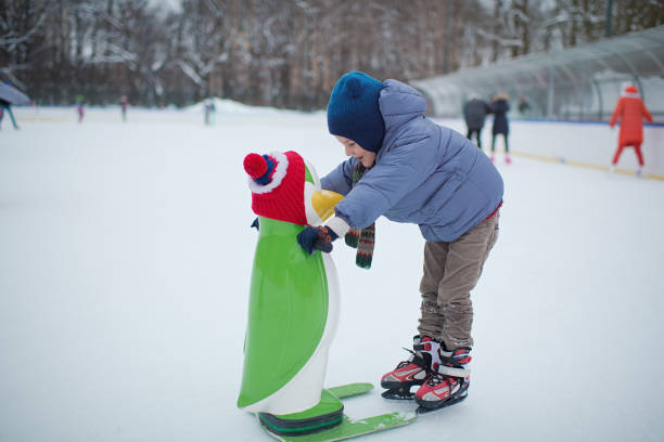 Child learns ice-skating using a helper penguin