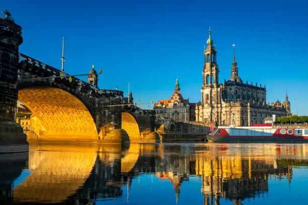 Augustus Bridge and Dresden Cathedral of the Holy Trinity or Hofkirche with reflections in the river Elbe. Dresden, Saxony, Germany