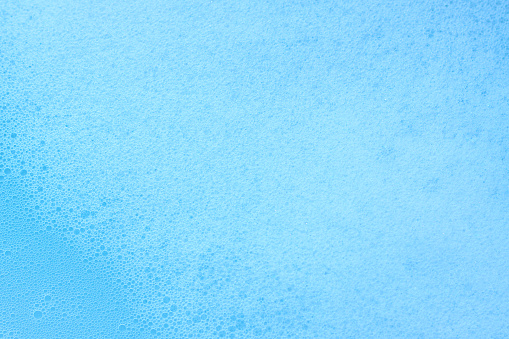Soap foam texture on blue background, Cleansing foam bubbles