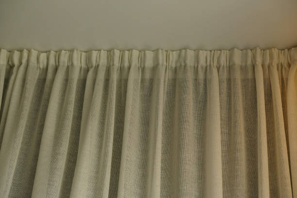 istock Close-up Cornice with drapes and white curtain or tulle. White wall, ceiling, cornice niche, curtains on the window. Corner hidden curtain rod. Interior details close up. 1413970860