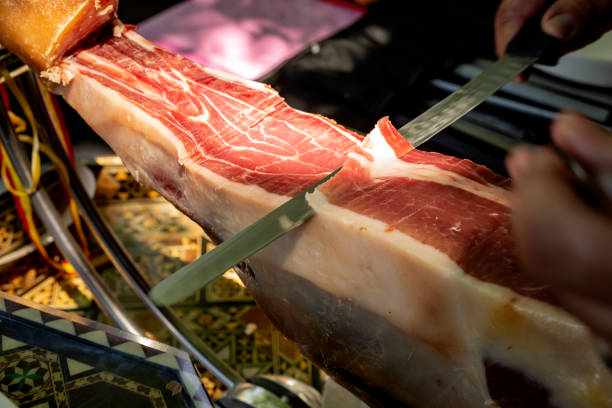 istock Cutting ham with tongs. Typical Spanish product 1413971852