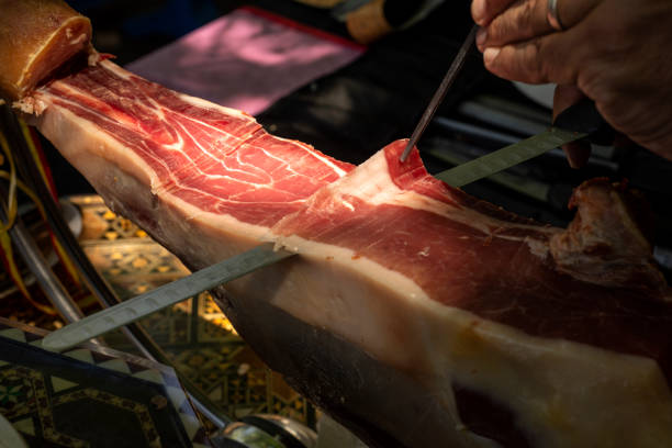 istock Cutting ham with tongs. Typical Spanish product 1413971853