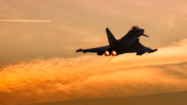 A Spanish Air Force Eurofighter Typhoon doing aerial maneuvers at sunset with orange background. Albacete, Spain 12 APR 2018. A Spanish Air Force Eurofighter Typhoon doing aerial maneuvers at sunset with orange background. High quality photo nato stock pictures, royalty-free photos & images