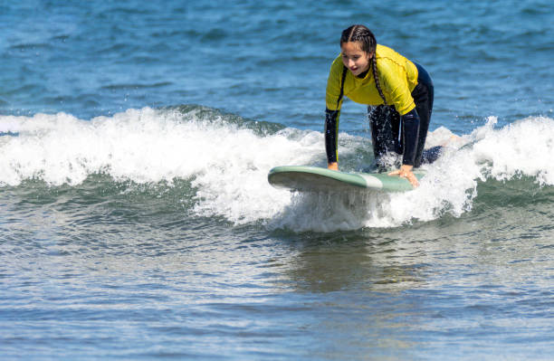 istock Woman kneeling on a surfboard 1413975065