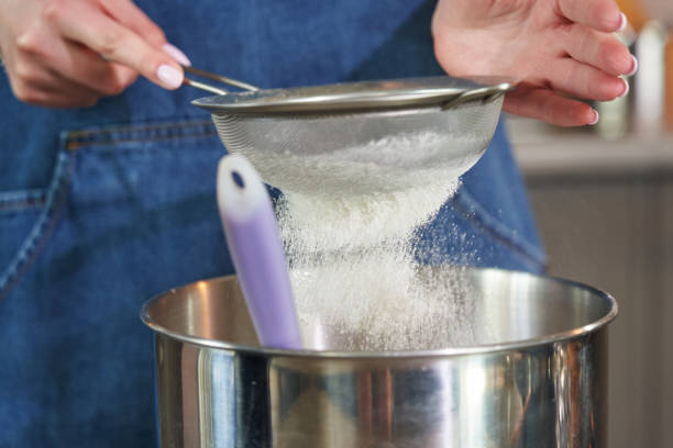 istock female hands sift flour through a sieve close-up 1413977133