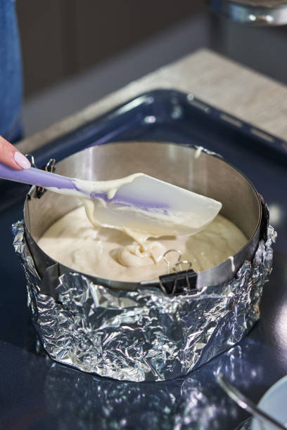 istock female hands distribute batter from a round iron baking dish with a spatula 1413977141