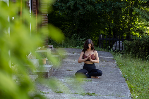 Calming and relaxing view of a woman sitting in a lotus posture preparing to meditate