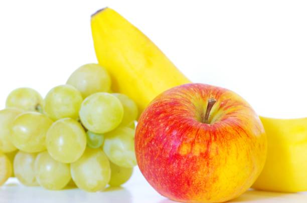Different varieties of the green and red grapes and apples on white surfaces in the studio