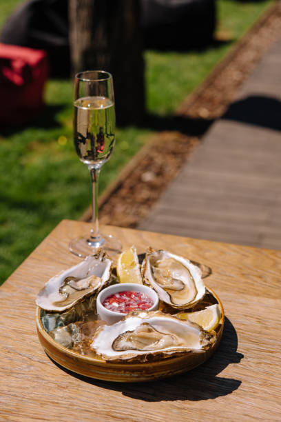 istock Opened oysters and lemon with white wine on the table 1413986820
