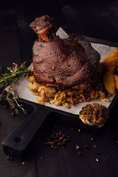 istock Roasted pork knuckle eisbein with on wooden cutting board 1413987989
