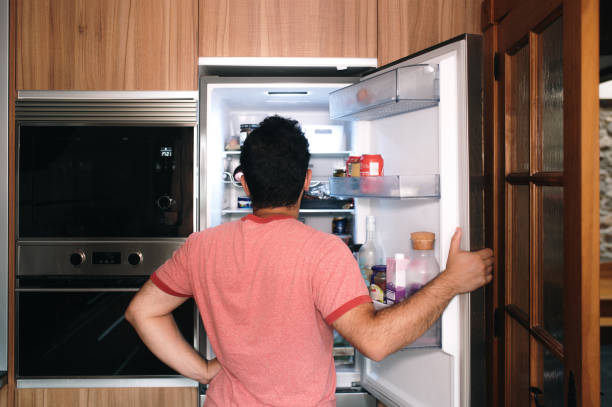 istock Rear view of a person looking inside a refrigerator 1413991173
