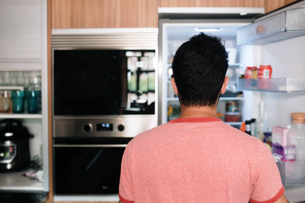 istock Rear view of a person looking inside a refrigerator 1413991191