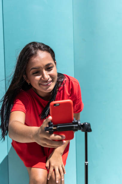 vlogger grabando contenido para sus redes sociales con un teléfono móvil en el parque de la ciudad - star of india fotografías e imágenes de stock