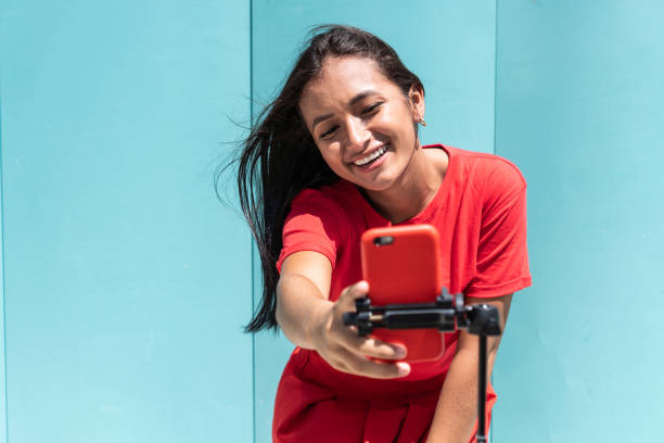 femme enregistrant du contenu pour ses réseaux sociaux avec un téléphone portable dans un parc de la ville - native american audio photos et images de collection