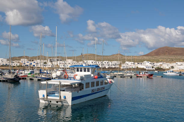 La Graciosa, Canary islands, Spain - January 08, 2009: Ferry for transporting passengers and boats anchored in the Marina of the town of Caleta del Sebo