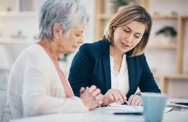 consultor financeiro falante ajudando idosos com papelada, orçamento de aposentadoria e gestão de fundos de pensão. trabalhador financeiro explicando e mostrando idosa onde assinar vai assinar acordo e contrato bancário - senior adult retirement financial advisor finance - fotografias e filmes do acervo