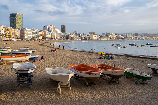 Gran Canaria, Canary islands, Spain - March 14, 2019: Fishing boats and panoramic view of Las Canteras beach in the city of Las Palmas, at sunset