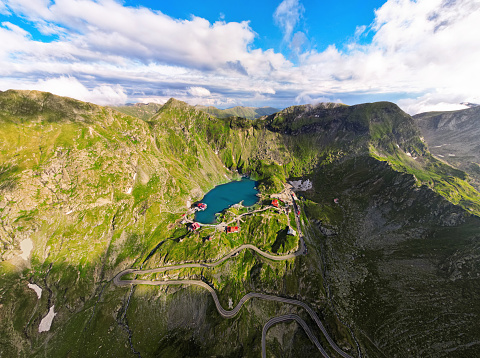 Aerial drone wide view of nature in Romania. Transfagarasan route in Carpathian mountains, Balea Lake resort and rocky slopes covered with greenery