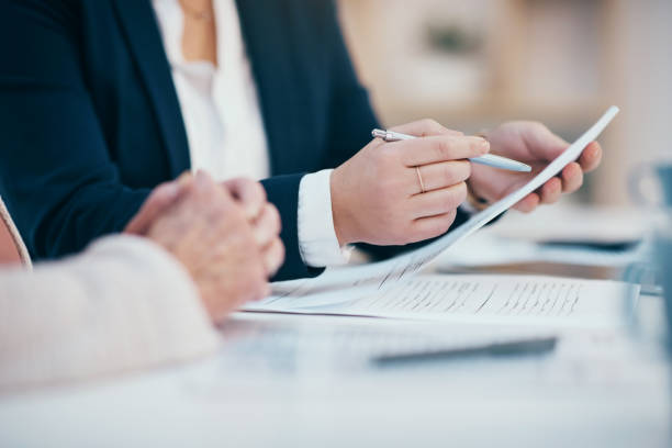Hands closeup on contact, legal settlement or financial report while reading and making notes. Lawyer team doing work and analyzing documents. Lawyers looking through client finance data together stock photo
