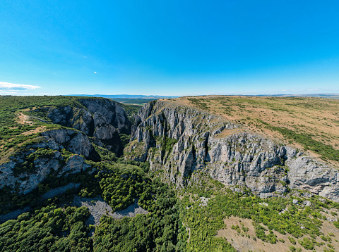 Aerial drone view of a rocky canyon in Romania. Rocky cliffs with greenery