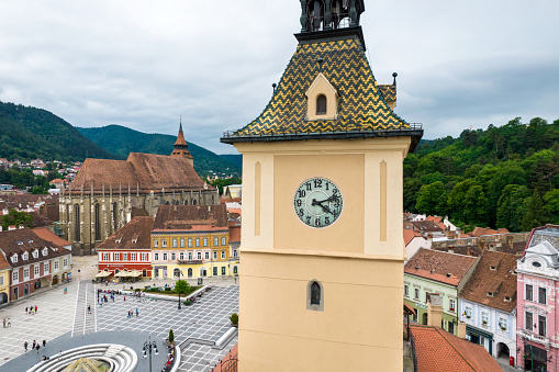 Aerial drone view of The Council Square in Brasov, Romania. Old city centre with County Museum of History, Black Church on the background, buildings, people