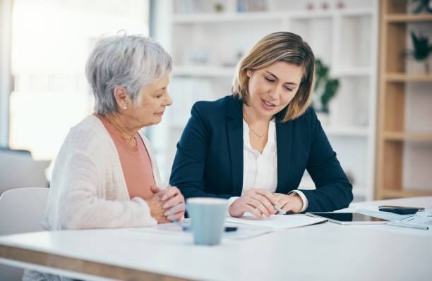 Retirement planning, asset management and financial advice with a senior woman and her advisor, broker or investment agent. Talking, discussing and planning savings, finance and wealth for the future stock photo