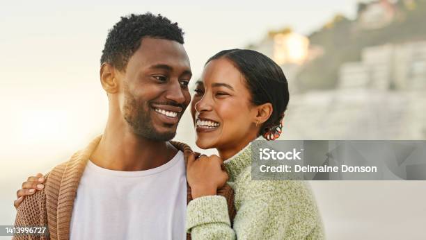 Fun Free And Happy Couple Laughing And Hugging At The Beach Enjoying Fresh Air And Time Together Young Lovers Talking And Bonding While Being Affectionate Sharing A Funny Joke While Walking Stock Photo - Download Image Now