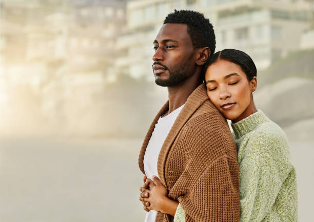 istock A young affectionate, loving and romantic couple hug on the beach and cuddle outdoors. Stylish caring african american couple showing love, affection and embracing on a romantic date at the beach 1413996729