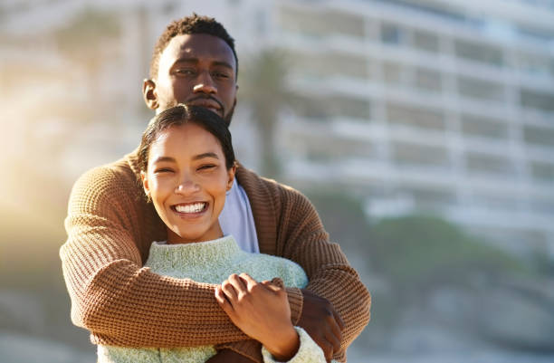 istock Loving, happy and interracial couple hugging and embracing while spending time outdoors and bonding on vacation. Portrait of boyfriend and girlfriend sharing a romantic moment while on holiday 1413996766