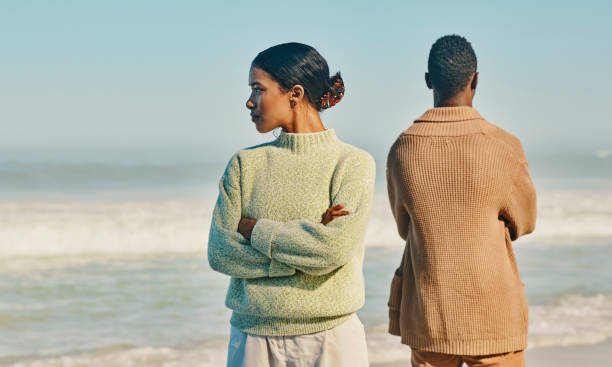 problèmes de couple, de relation et de mariage tout en voyageant ensemble et en passant du temps à la plage. homme et femme bouleversés, malheureux et en colère s’ignorant après une bagarre, une dispute ou une querelle - black hair photos et images de collection