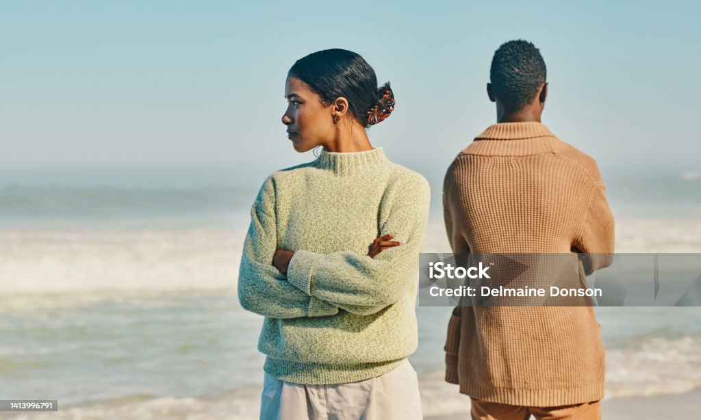 Couple, relationship and marriage problems while traveling together and spending time at the beach. Upset, unhappy and angry man and woman ignoring each other after a fight,  arguing or quarrel Couple - Relationship Stock Photo