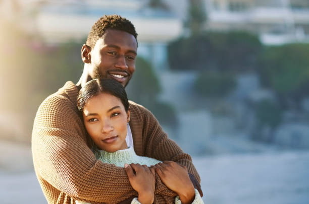istock Loving, happy and interracial couple hugging and embracing while spending time outdoors and bonding on vacation. Happy boyfriend and girlfriend sharing a romantic moment while on holiday together 1413997386