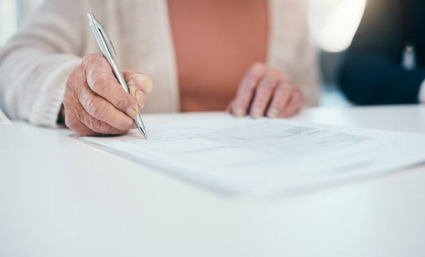 istock Senior hand signing finance paperwork, will agreement and pension fund contract while planning budget, banking and investing. Closeup of old, aged and retired woman calculating expenses and spending 1413997939